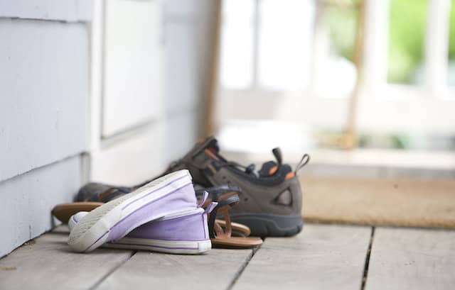 Pairs of shoes on a door mat from Public Health Image Library